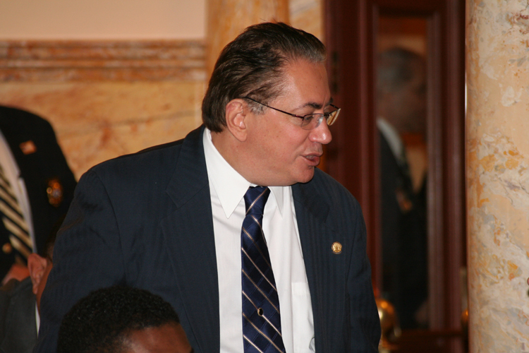 Senator Nicholas Sacco, D-Hudson, speaks with a colleague on the Senate floor regarding legislation being voted on.
