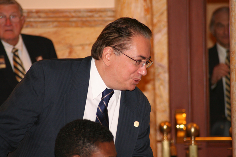 Senator Nicholas Sacco, D-Hudson, speaks with a colleague on the Senate floor regarding legislation pending a vote.